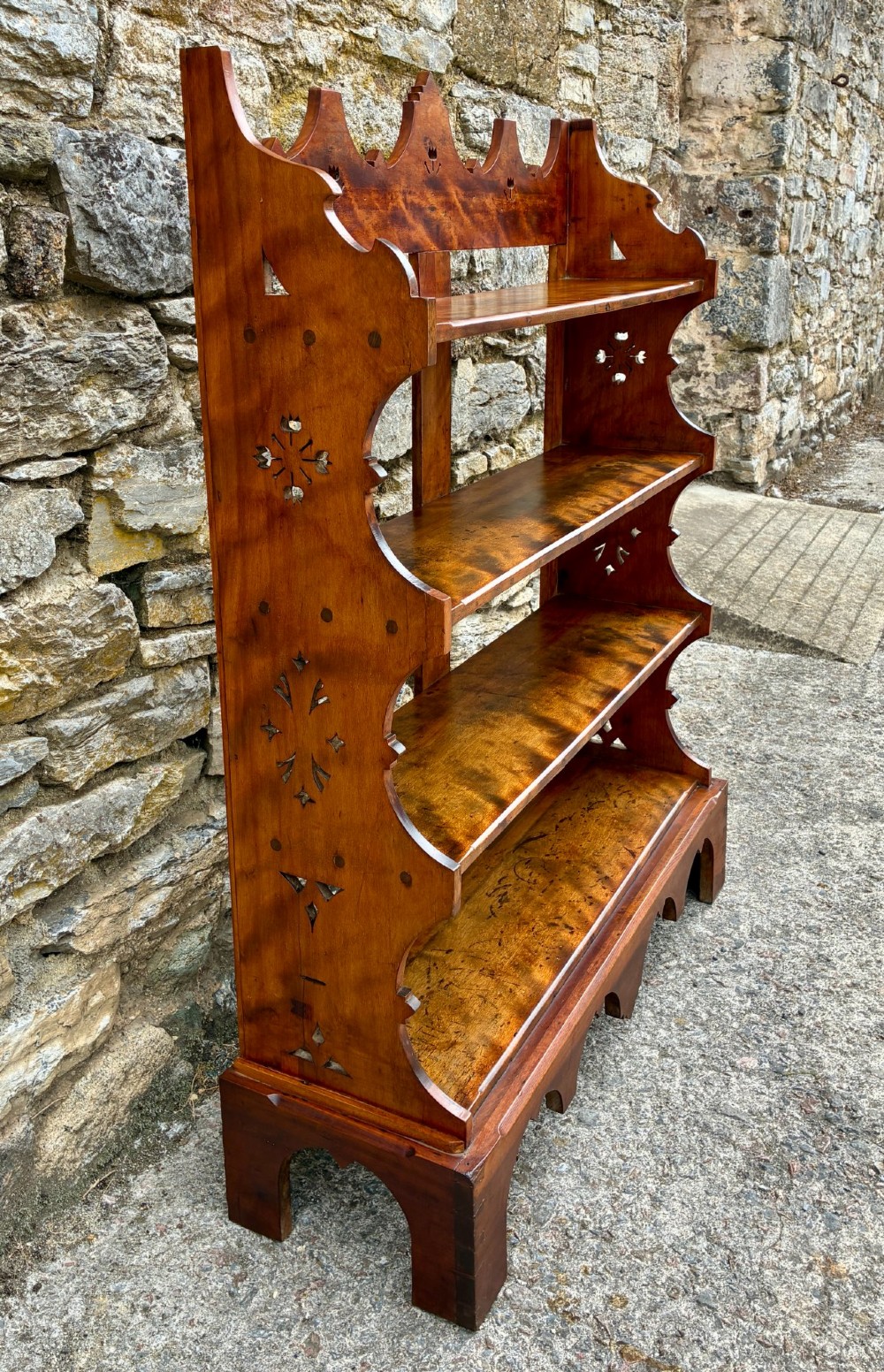 An Arts and Crafts satinwood open bookcase featuring four tiered shelves with a scalloped top gallery, shaped sides, and decorative pierced cut-outs. View VII