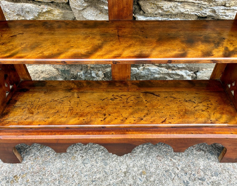 An Arts and Crafts satinwood open bookcase featuring four tiered shelves with a scalloped top gallery, shaped sides, and decorative pierced cut-outs. View X