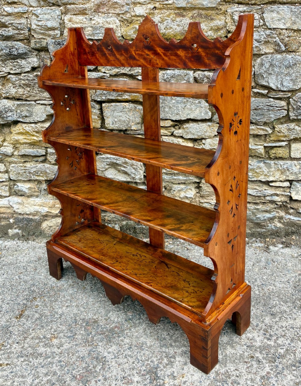 An Arts and Crafts satinwood open bookcase featuring four tiered shelves with a scalloped top gallery, shaped sides, and decorative pierced cut-outs. View XI