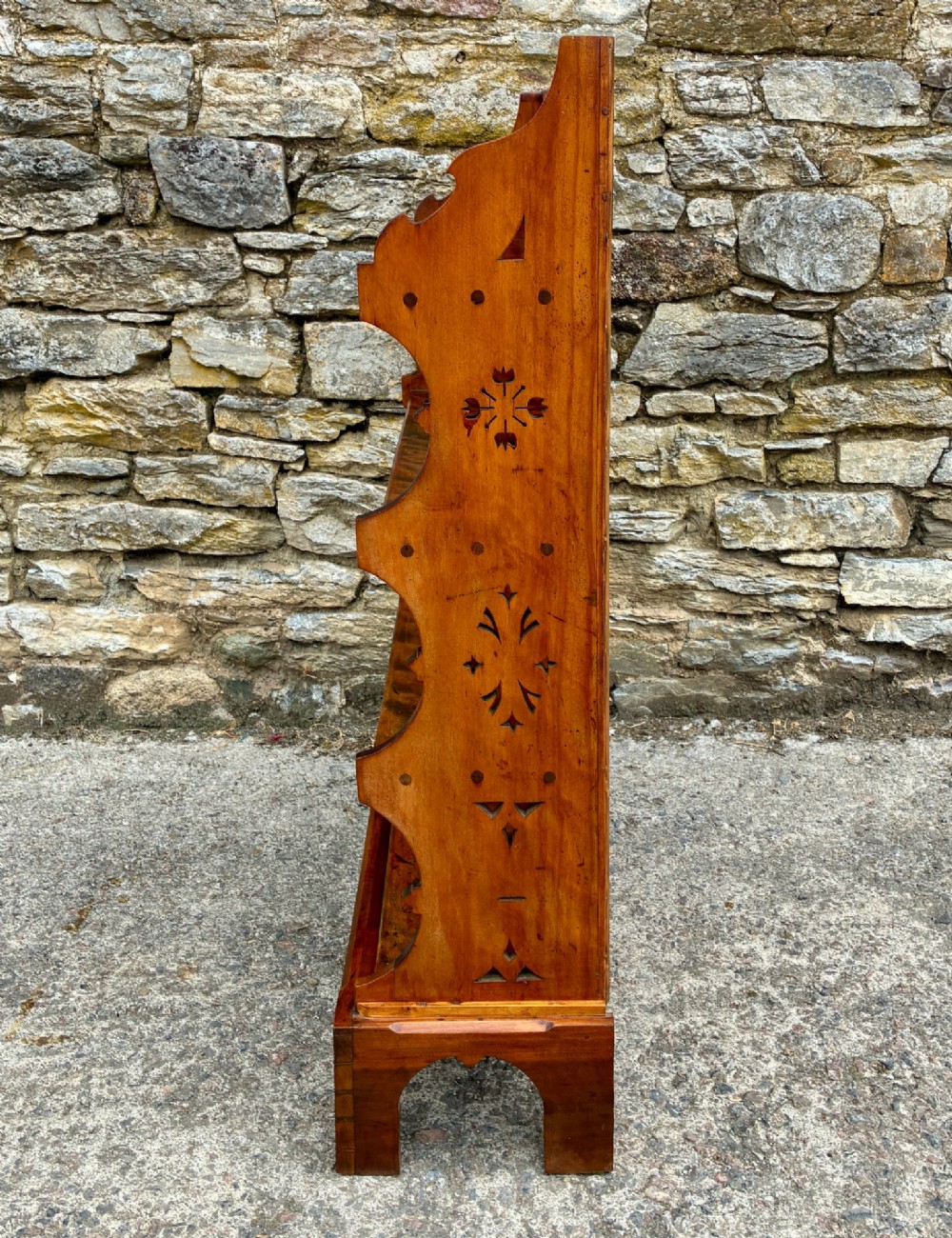 An Arts and Crafts satinwood open bookcase featuring four tiered shelves with a scalloped top gallery, shaped sides, and decorative pierced cut-outs. View XII