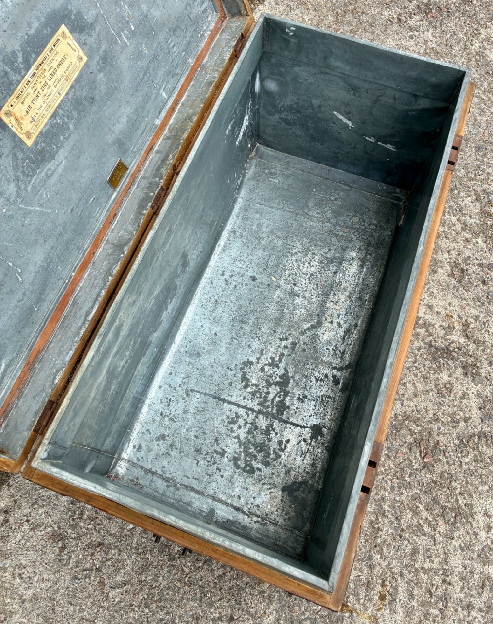An antique rectangular pine campaign trunk with dark metal corner brackets, a brass escutcheon, and visible natural wood grain. View IV