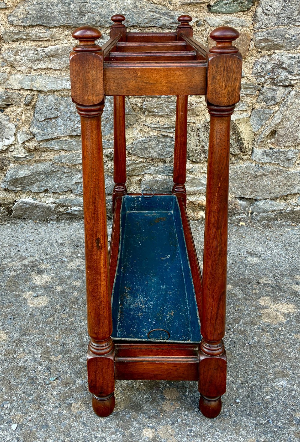 A Victorian mahogany umbrella stand with four divided top sections, turned support legs with ball finials, and a removable blue painted metal drip tray. View IV