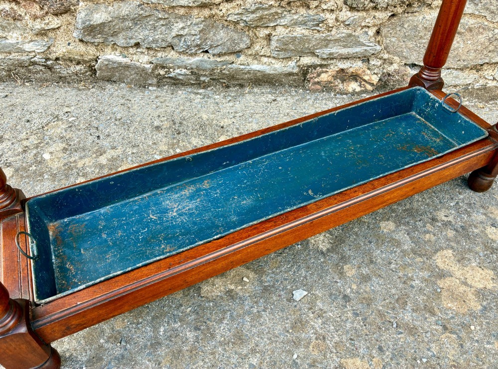 A Victorian mahogany umbrella stand with four divided top sections, turned support legs with ball finials, and a removable blue painted metal drip tray. View VIII
