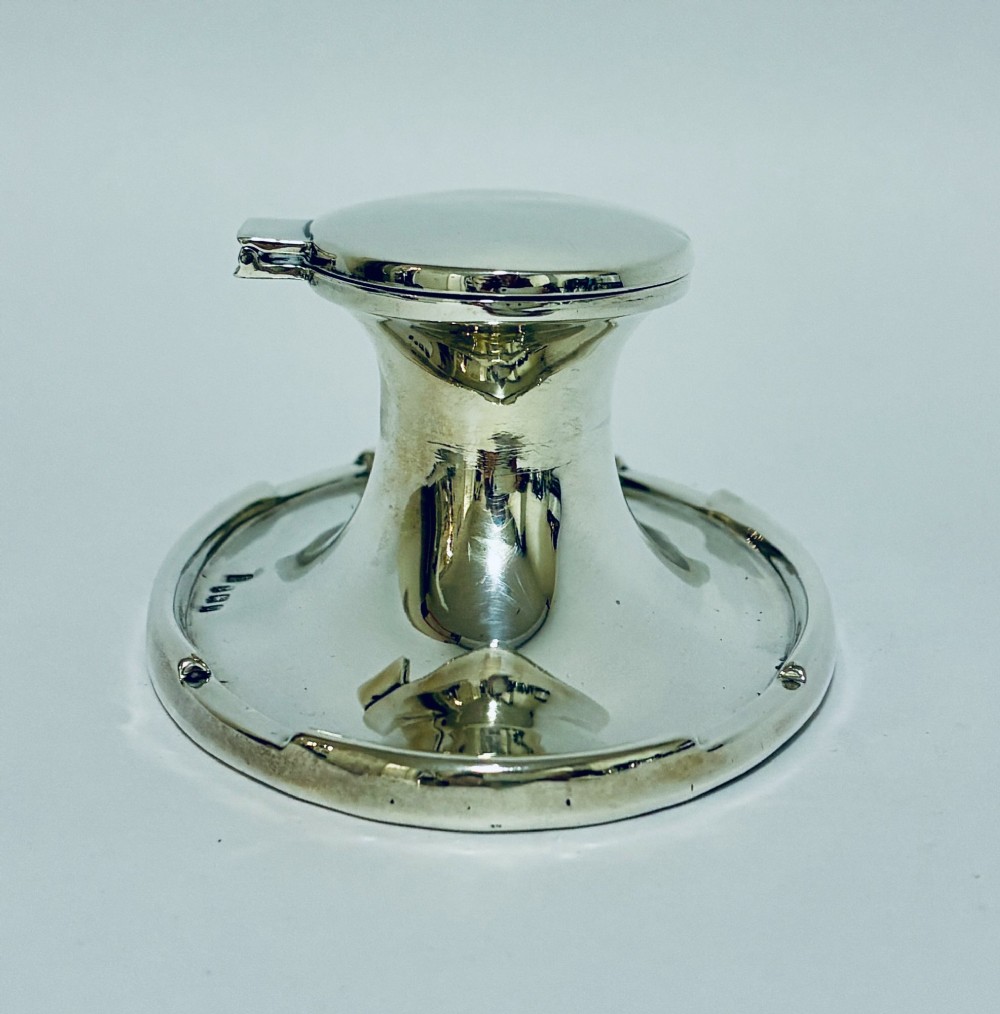 A solid silver capstan-shaped inkwell with a broad flared circular base and a hinged domed lid. View VII