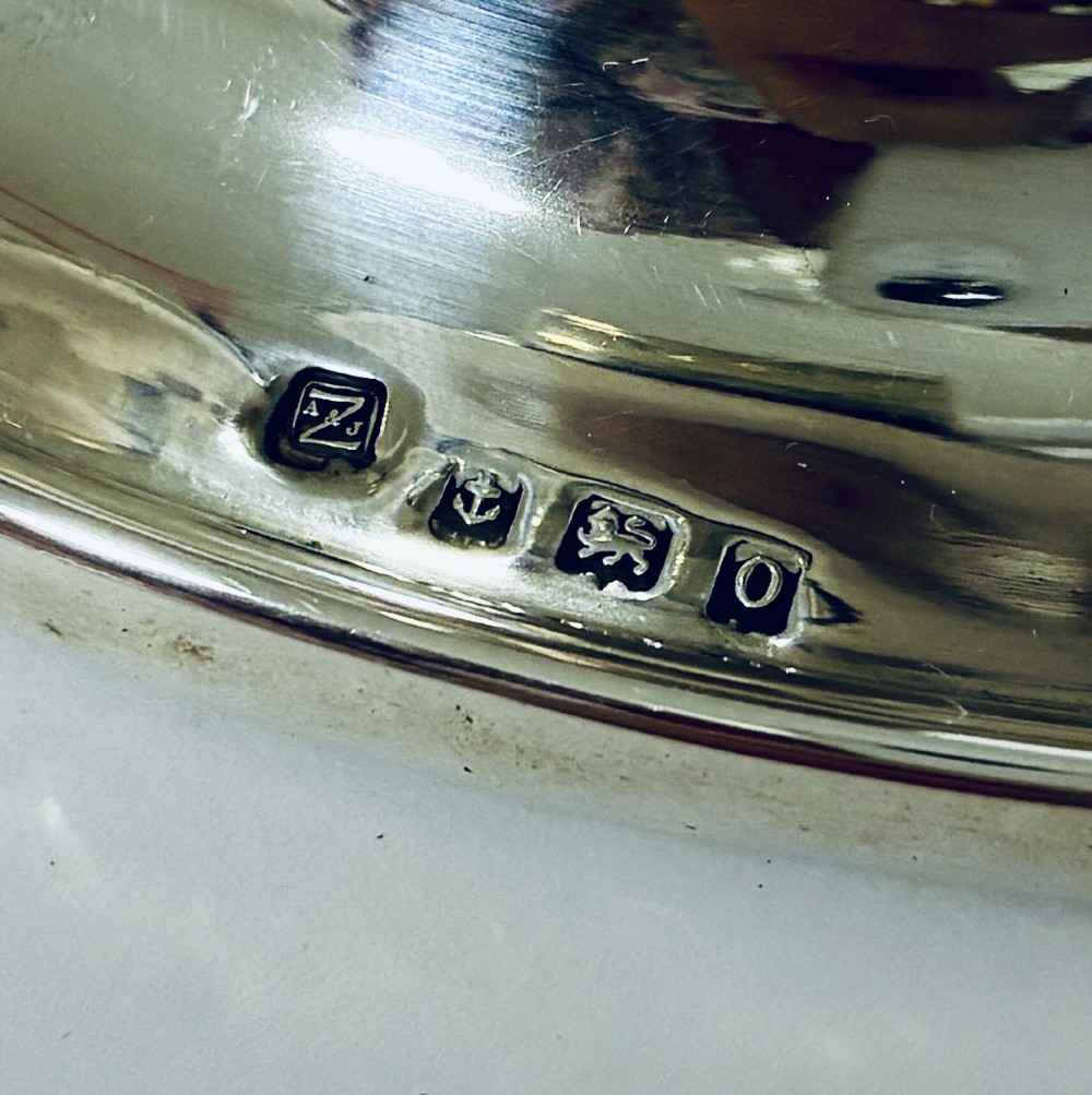 A solid silver capstan-shaped inkwell with a broad flared circular base and a hinged domed lid. View VIII