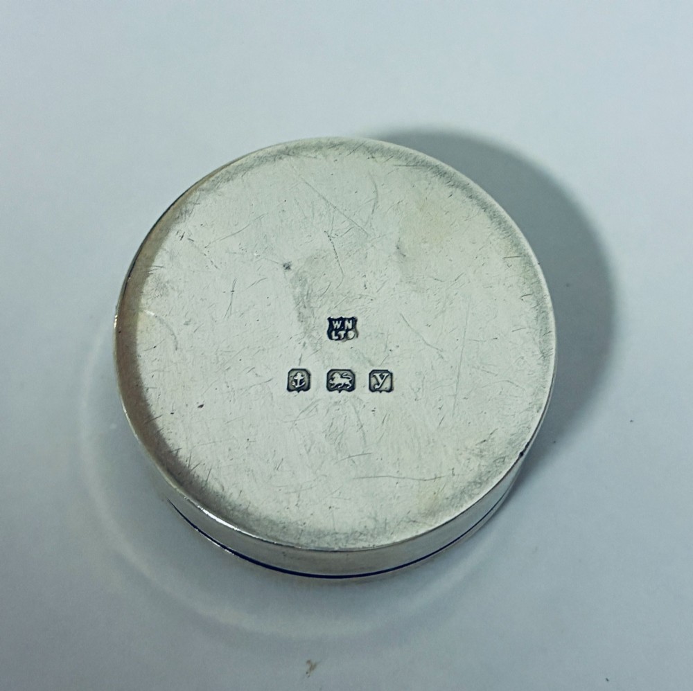 A round antique silver pill box featuring engine-turned geometric patterns on the lid. View III