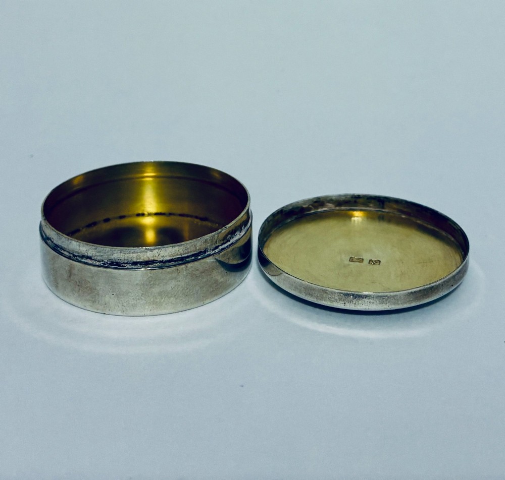 A round antique silver pill box featuring engine-turned geometric patterns on the lid. View IV