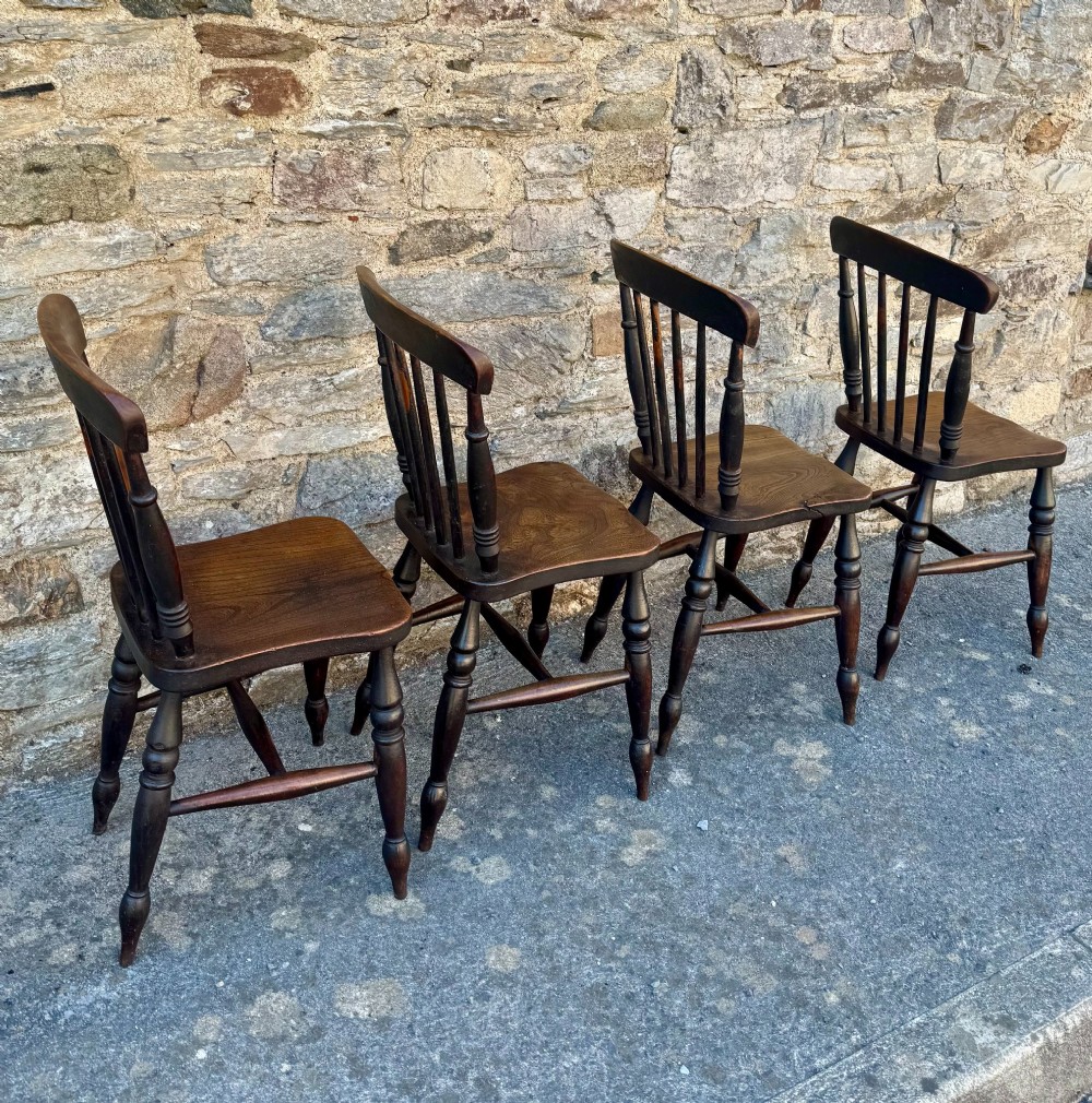 A set of four dark brown Victorian wooden kitchen chairs featuring spindle backs, shaped seats, and turned legs. View VII