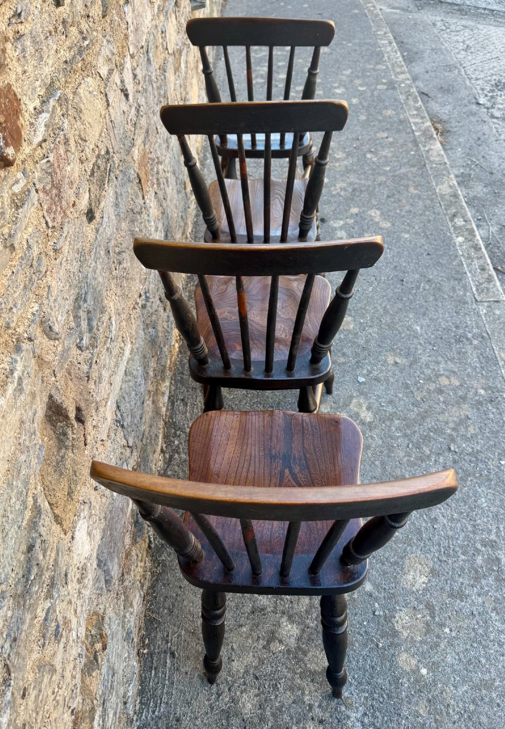 A set of four dark brown Victorian wooden kitchen chairs featuring spindle backs, shaped seats, and turned legs. View VIII
