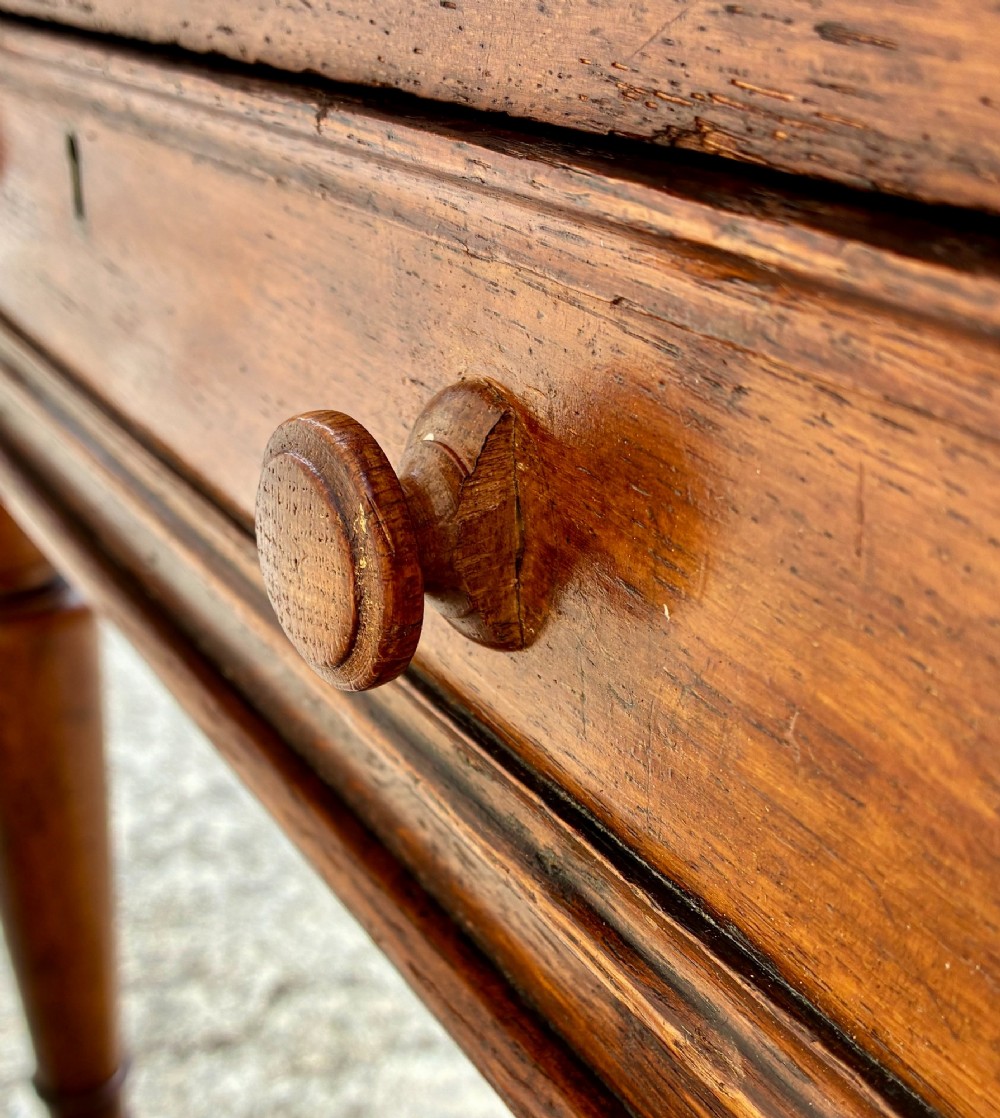 A Victorian oak writing desk featuring a green leather insert top, frieze drawers with wooden turned knobs, and turned legs with brass castors. View XI