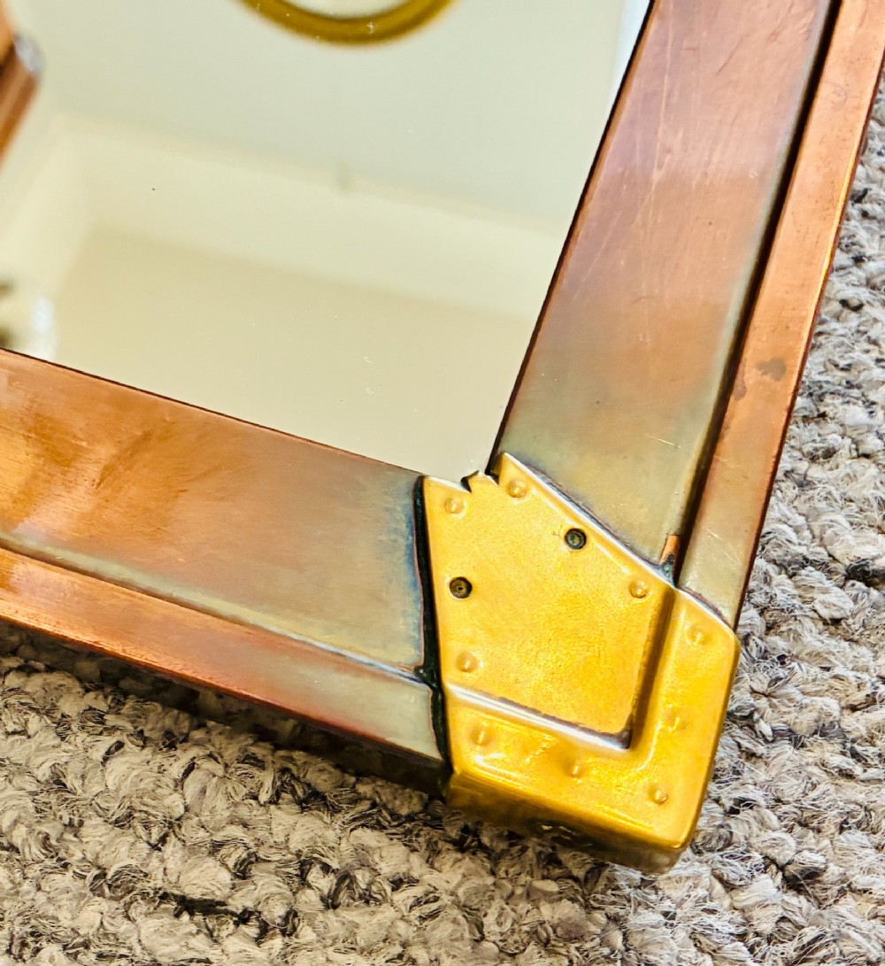 A rectangular wall mirror featuring a sheet copper frame reinforced with riveted brass corner plates. View III