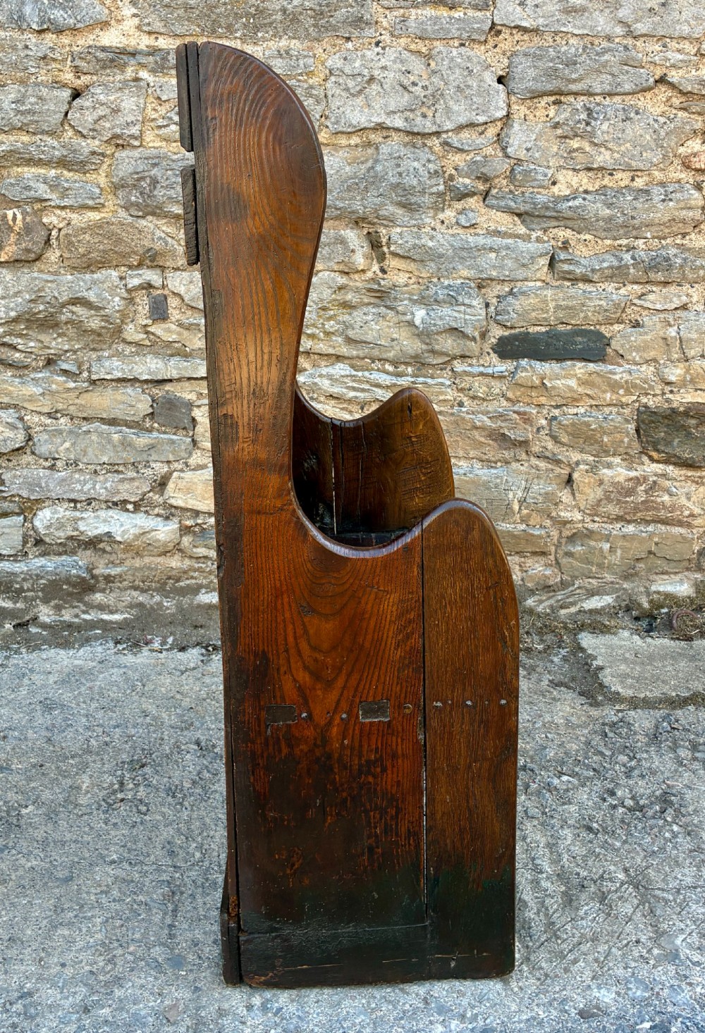 A dark oak primitive lambing chair featuring high winged sides, a tall two-panel back, a solid timber seat, and an enclosed box base. View XI