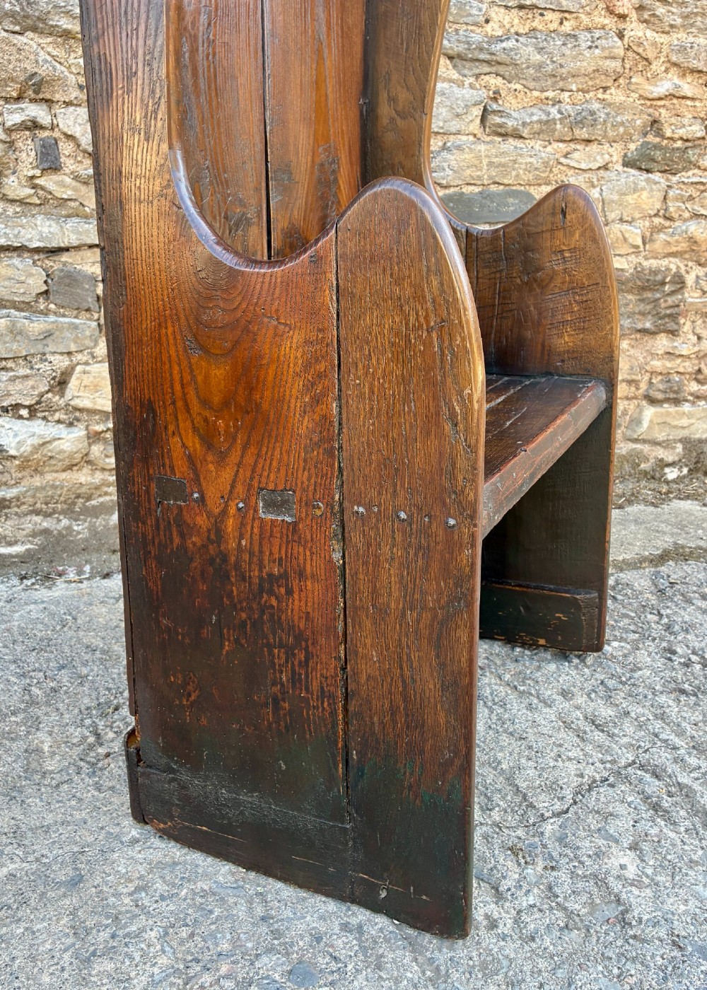 A dark oak primitive lambing chair featuring high winged sides, a tall two-panel back, a solid timber seat, and an enclosed box base. View XIII