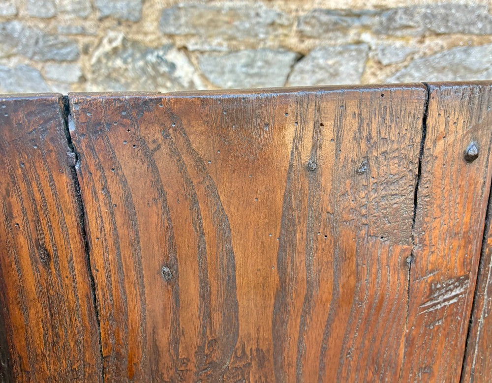 A dark oak primitive lambing chair featuring high winged sides, a tall two-panel back, a solid timber seat, and an enclosed box base. View XV