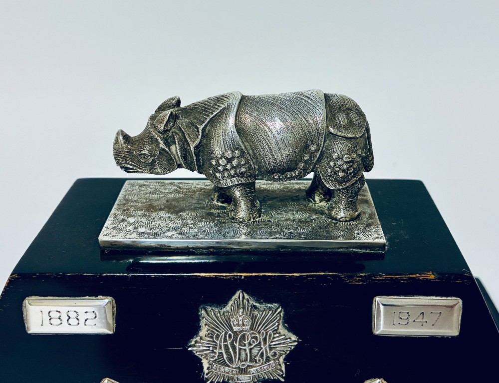 An antique silver presentation trophy featuring a detailed Indian rhinoceros figurine mounted atop a stepped ebonised wooden plinth with silver plaques. View II