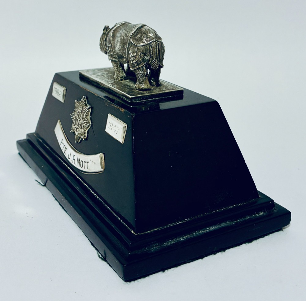 An antique silver presentation trophy featuring a detailed Indian rhinoceros figurine mounted atop a stepped ebonised wooden plinth with silver plaques. View IV