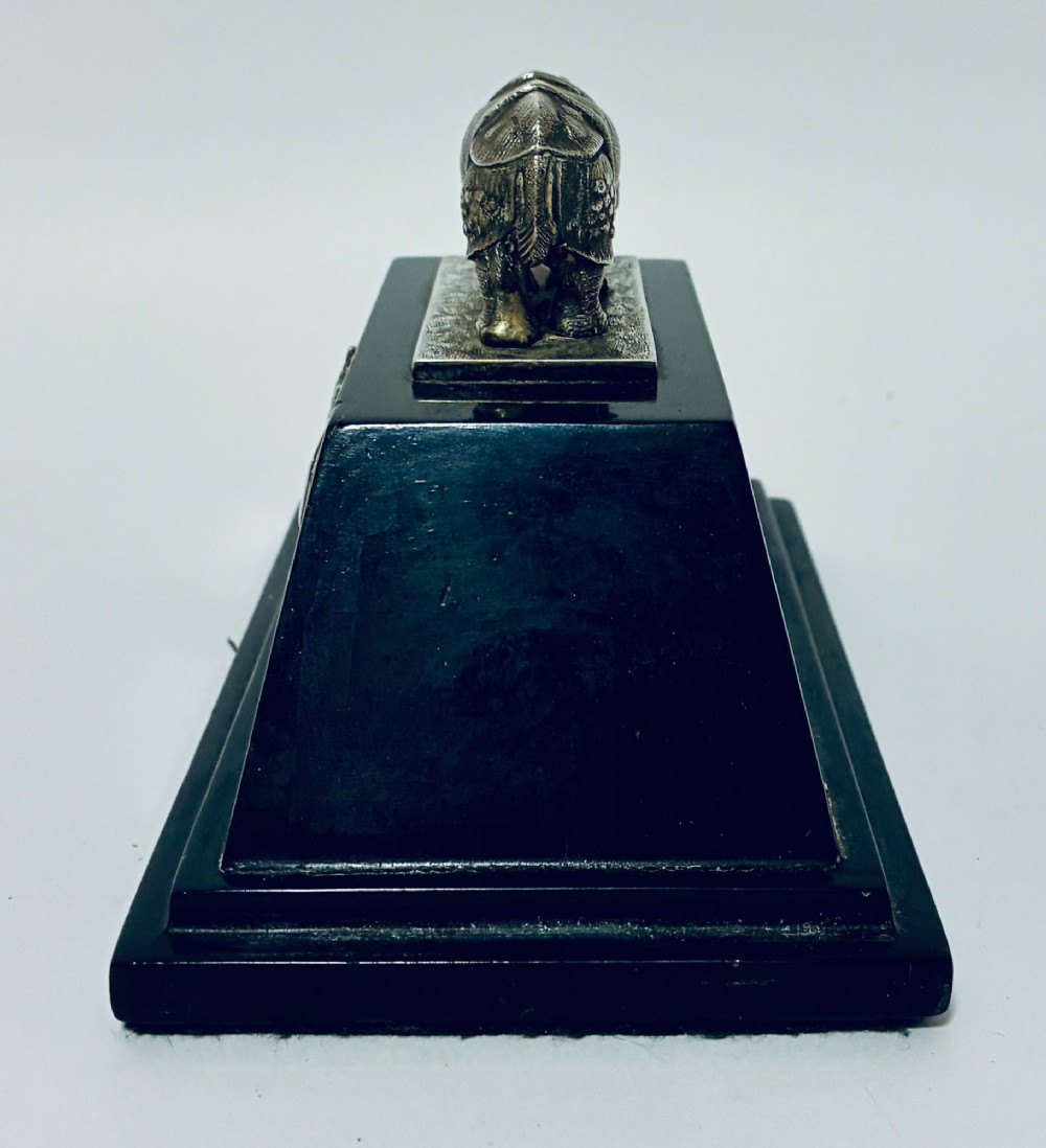 An antique silver presentation trophy featuring a detailed Indian rhinoceros figurine mounted atop a stepped ebonised wooden plinth with silver plaques. View V
