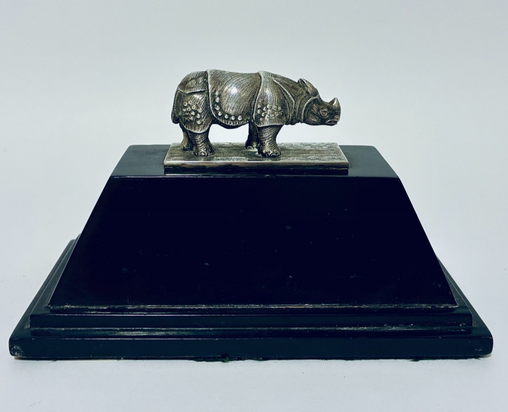 An antique silver presentation trophy featuring a detailed Indian rhinoceros figurine mounted atop a stepped ebonised wooden plinth with silver plaques. View VI