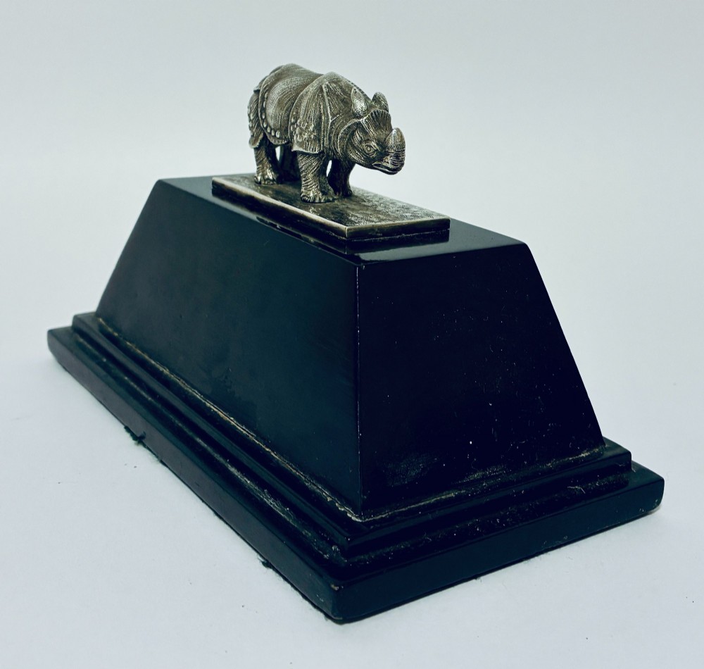 An antique silver presentation trophy featuring a detailed Indian rhinoceros figurine mounted atop a stepped ebonised wooden plinth with silver plaques. View VIII