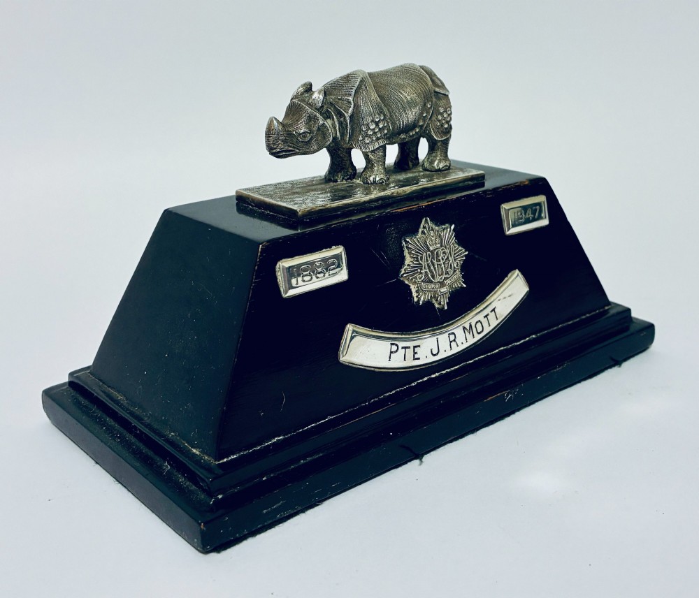 An antique silver presentation trophy featuring a detailed Indian rhinoceros figurine mounted atop a stepped ebonised wooden plinth with silver plaques. View IX