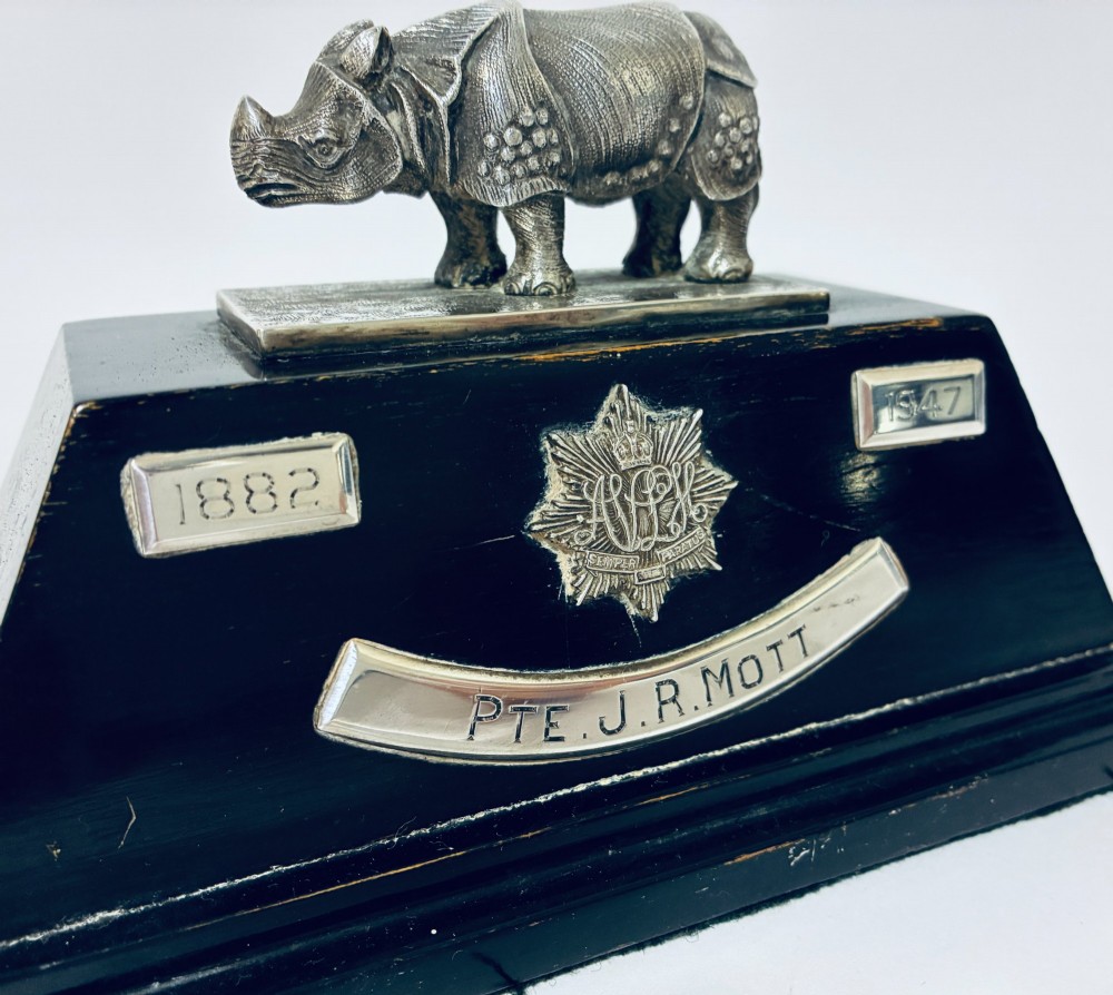 An antique silver presentation trophy featuring a detailed Indian rhinoceros figurine mounted atop a stepped ebonised wooden plinth with silver plaques. View X