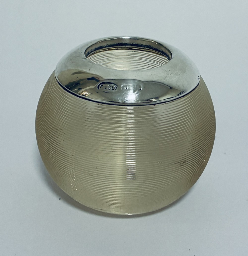 A spherical clear ribbed glass match striker featuring a polished hallmarked silver rim at the top opening.