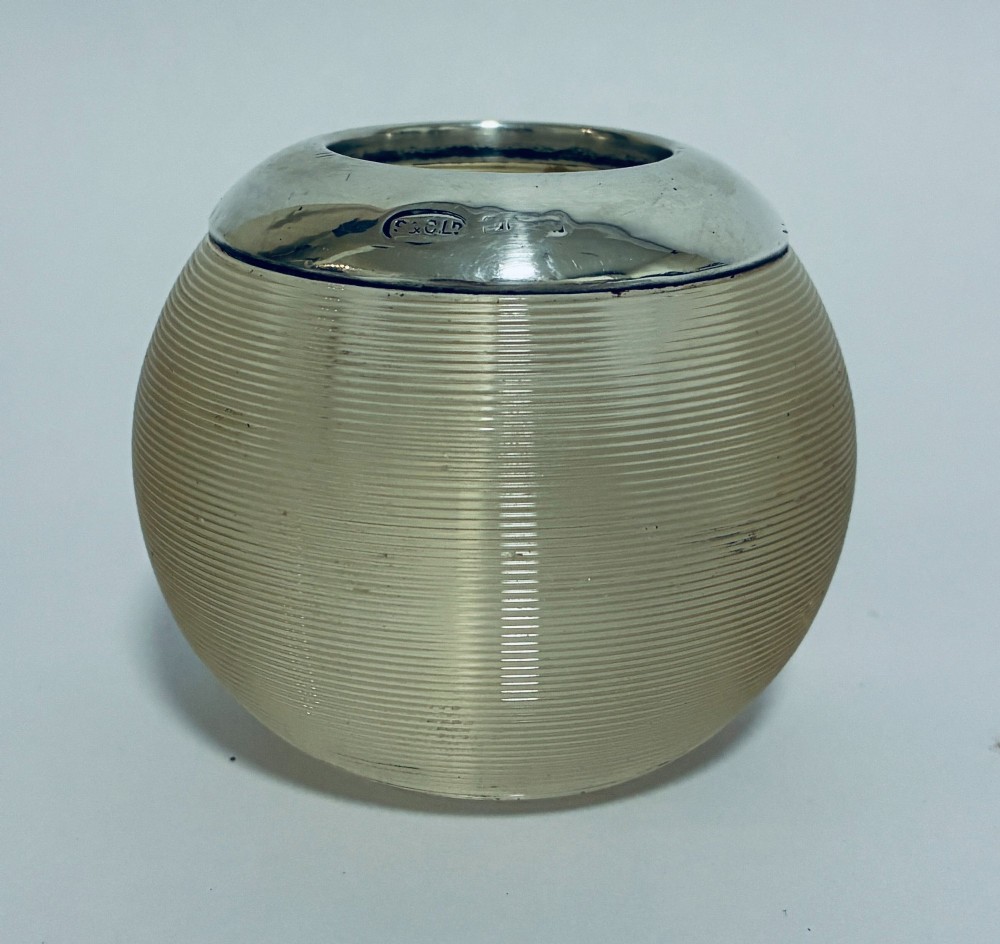 A spherical clear ribbed glass match striker featuring a polished hallmarked silver rim at the top opening. View II