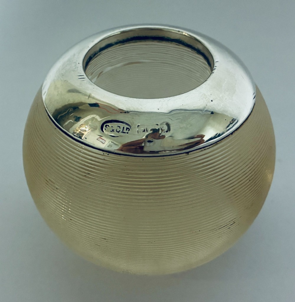 A spherical clear ribbed glass match striker featuring a polished hallmarked silver rim at the top opening. View III