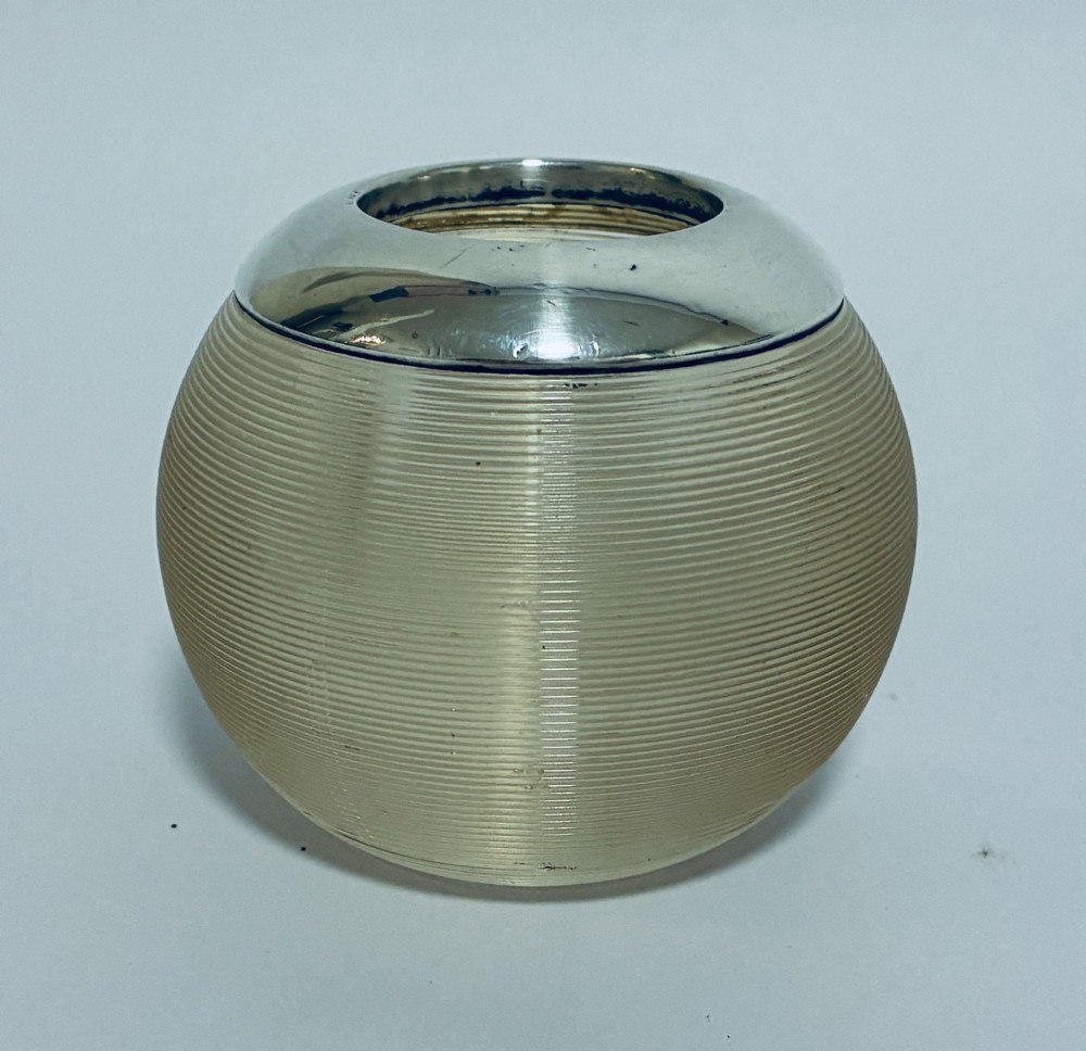 A spherical clear ribbed glass match striker featuring a polished hallmarked silver rim at the top opening. View IV