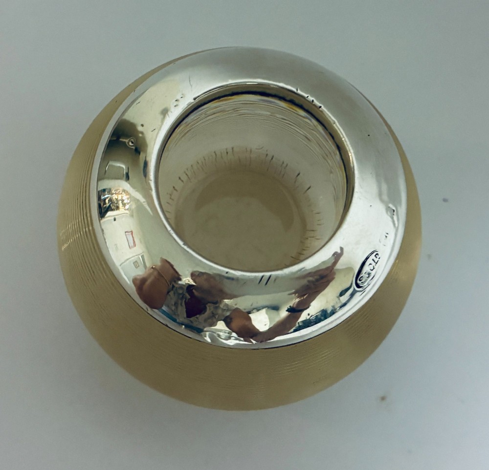 A spherical clear ribbed glass match striker featuring a polished hallmarked silver rim at the top opening. View VI