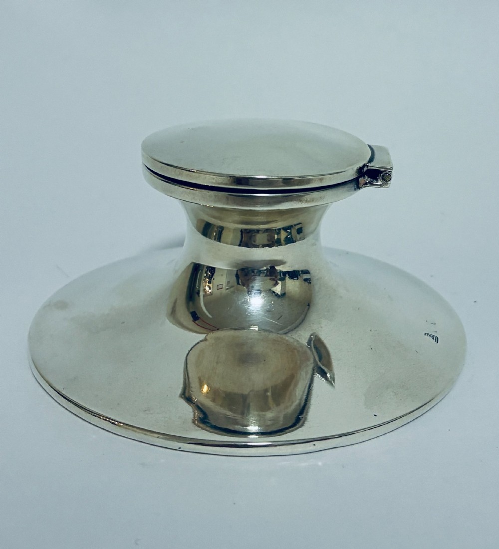 A polished silver capstan inkwell featuring a broad circular base, a tapered central waist, and a hinged flat lid. View II