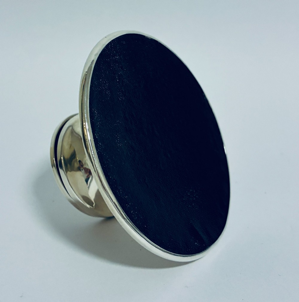 A polished silver capstan inkwell featuring a broad circular base, a tapered central waist, and a hinged flat lid. View XII