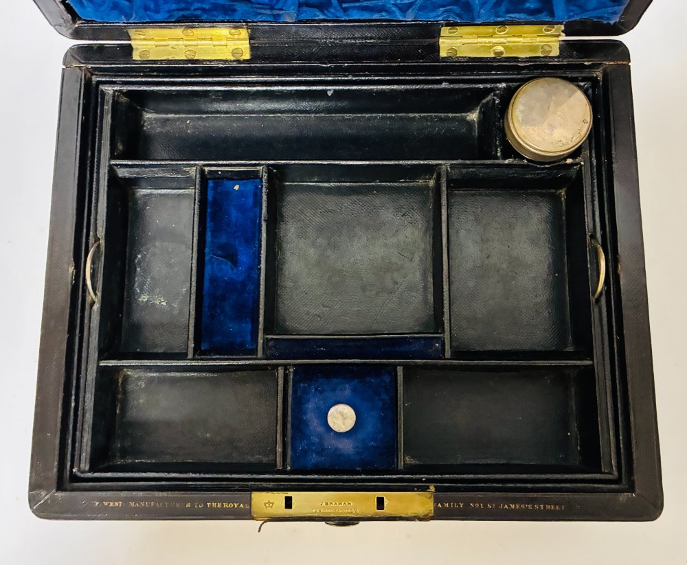 An open Victorian dark brown leather dressing case with a blue velvet-lined lid, brass lock, and compartmentalised interior sitting inside an outer leather travel box. View III