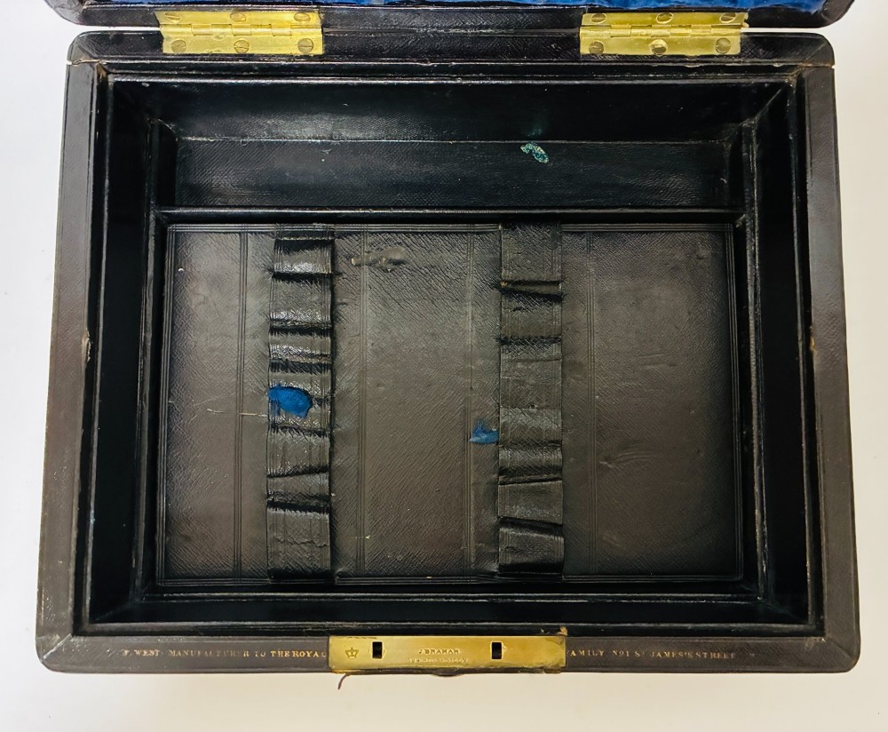 An open Victorian dark brown leather dressing case with a blue velvet-lined lid, brass lock, and compartmentalised interior sitting inside an outer leather travel box. View V