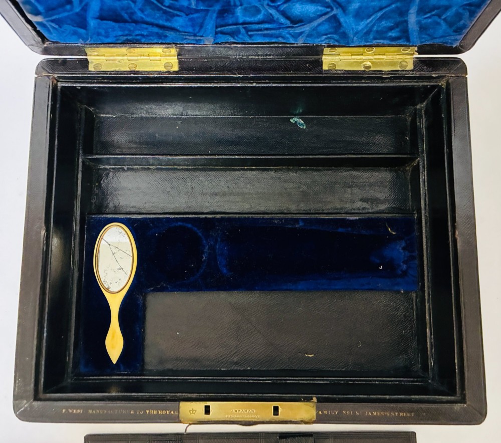 An open Victorian dark brown leather dressing case with a blue velvet-lined lid, brass lock, and compartmentalised interior sitting inside an outer leather travel box. View VI
