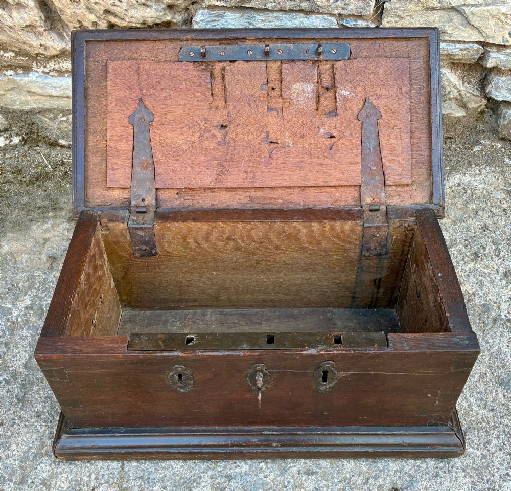 An 18th-century dark oak strong box featuring nail-head studs forming the date 1754 on the lid and three keyholes along the front fascia. View III