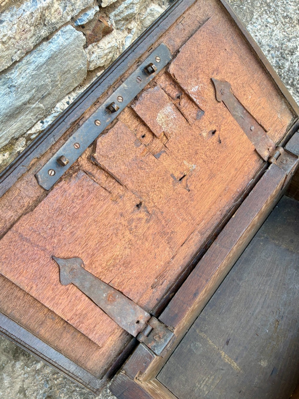 An 18th-century dark oak strong box featuring nail-head studs forming the date 1754 on the lid and three keyholes along the front fascia. View V