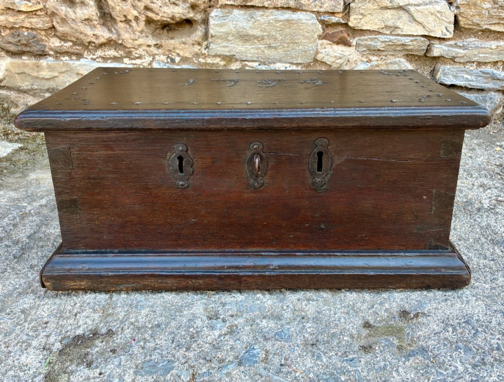 An 18th-century dark oak strong box featuring nail-head studs forming the date 1754 on the lid and three keyholes along the front fascia. View VII