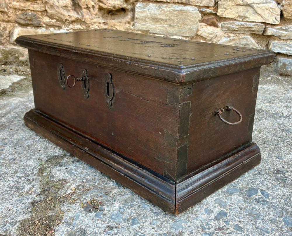 An 18th-century dark oak strong box featuring nail-head studs forming the date 1754 on the lid and three keyholes along the front fascia. View VIII