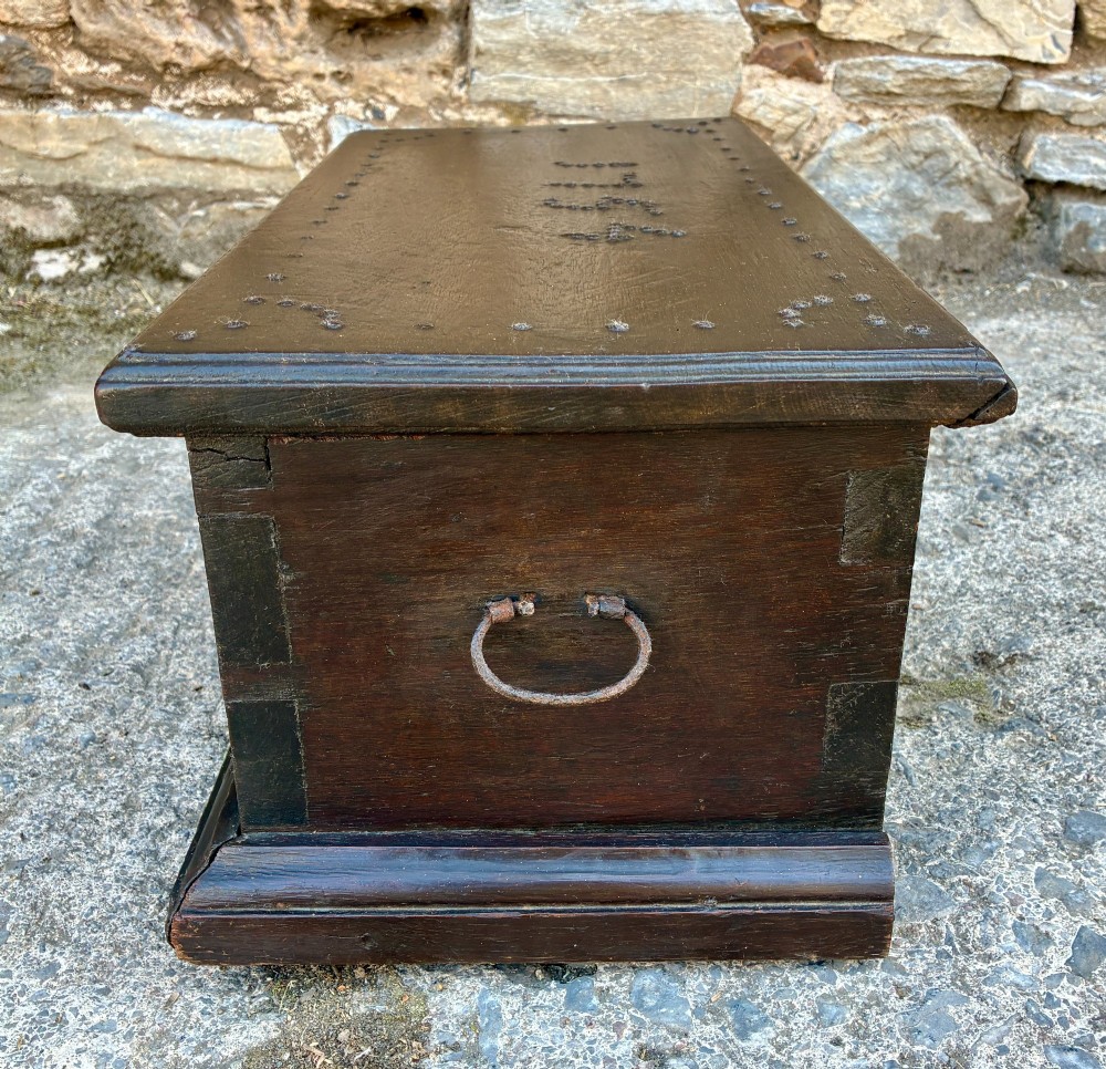 An 18th-century dark oak strong box featuring nail-head studs forming the date 1754 on the lid and three keyholes along the front fascia. View IX