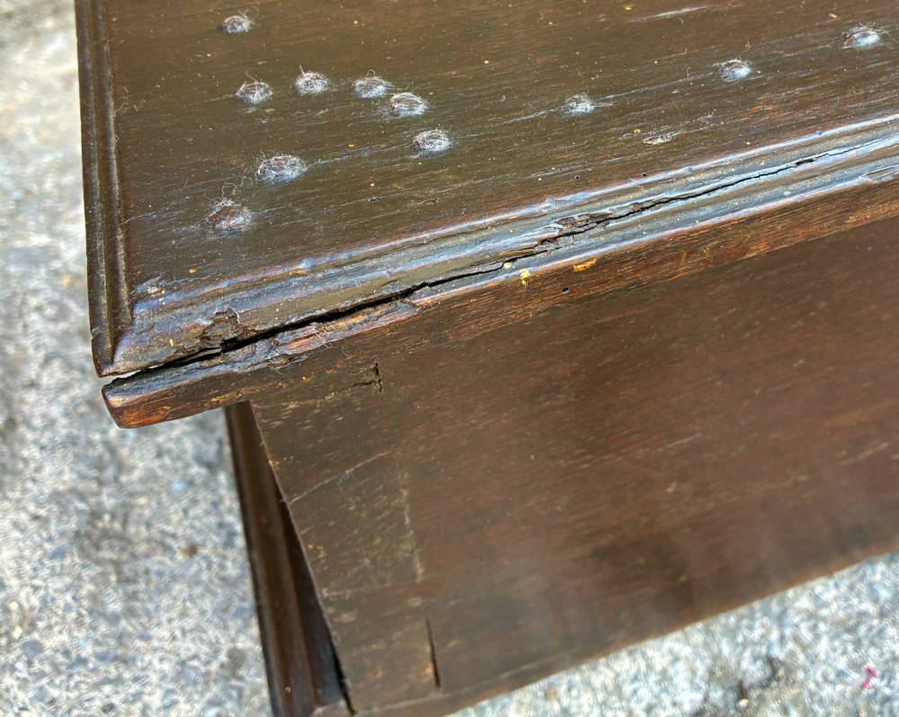 An 18th-century dark oak strong box featuring nail-head studs forming the date 1754 on the lid and three keyholes along the front fascia. View XI