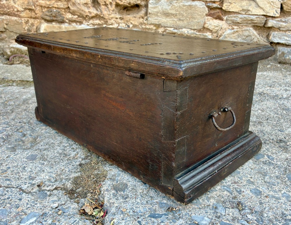 An 18th-century dark oak strong box featuring nail-head studs forming the date 1754 on the lid and three keyholes along the front fascia. View XII