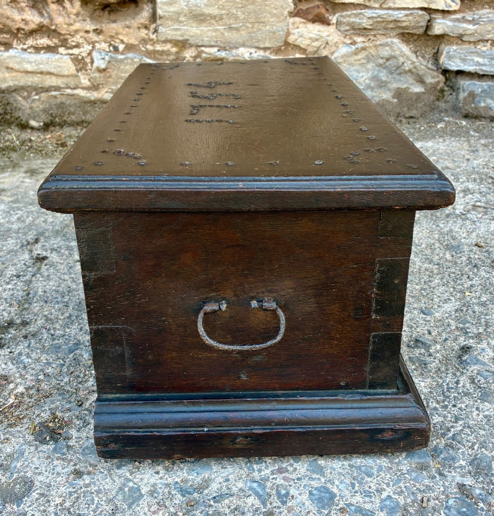 An 18th-century dark oak strong box featuring nail-head studs forming the date 1754 on the lid and three keyholes along the front fascia. View XIII