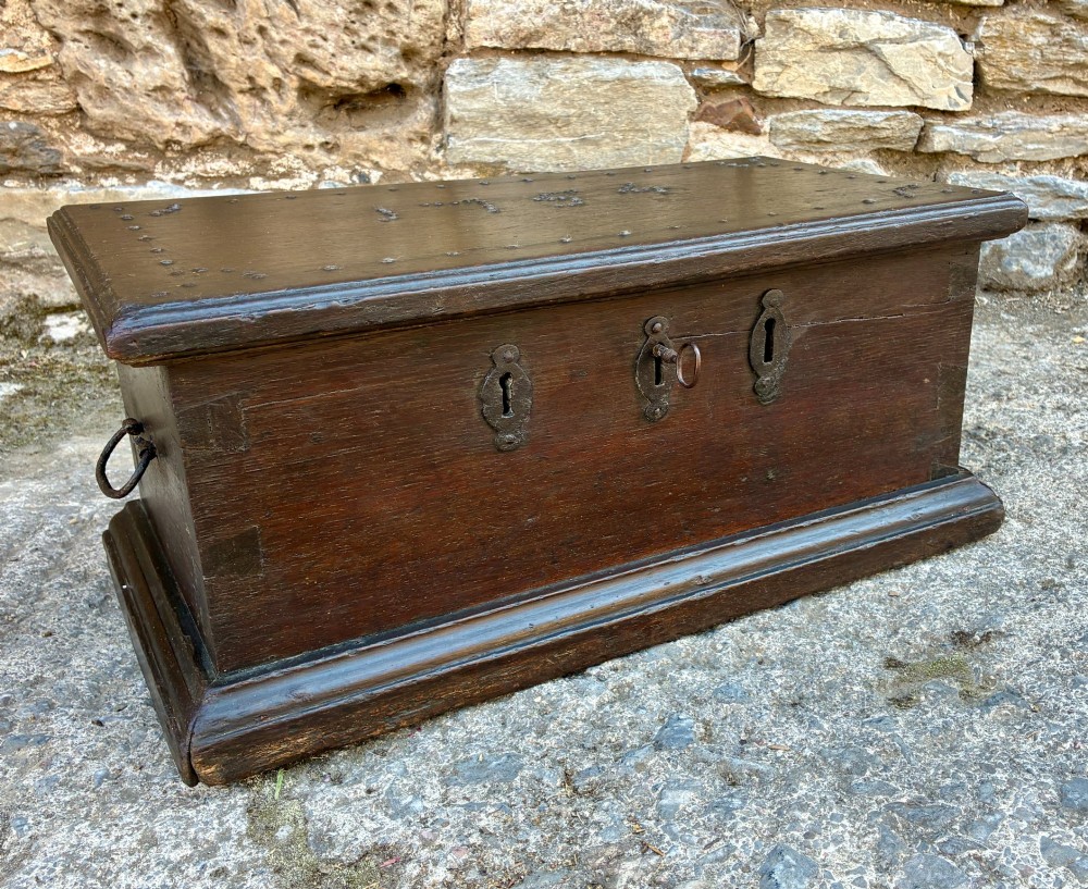 An 18th-century dark oak strong box featuring nail-head studs forming the date 1754 on the lid and three keyholes along the front fascia. View XV