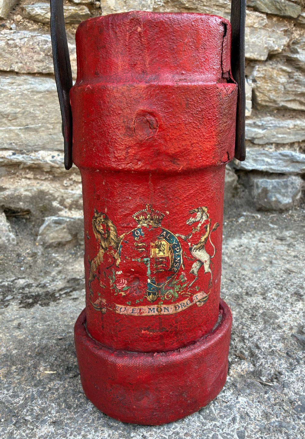 A cylindrical red leather military cordite carrier featuring a hand-painted Royal Coat of Arms and an attached leather handle. View II