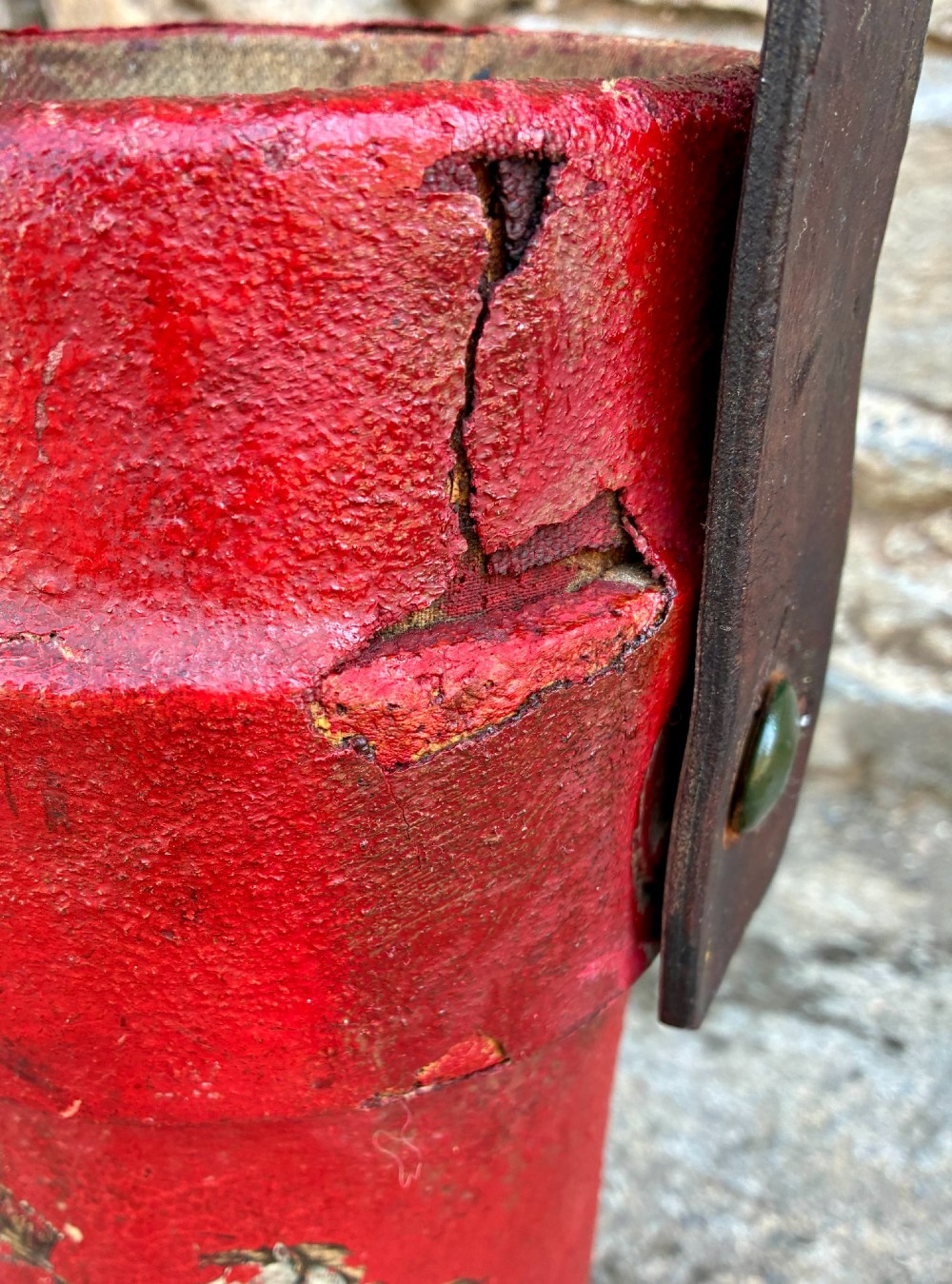 A cylindrical red leather military cordite carrier featuring a hand-painted Royal Coat of Arms and an attached leather handle. View VIII