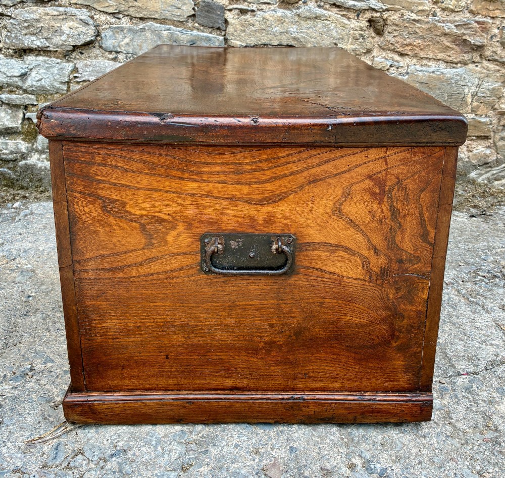 A rectangular antique elm blanket box featuring a hinged lid, visible wood grain, and a central keyhole escutcheon. View IX
