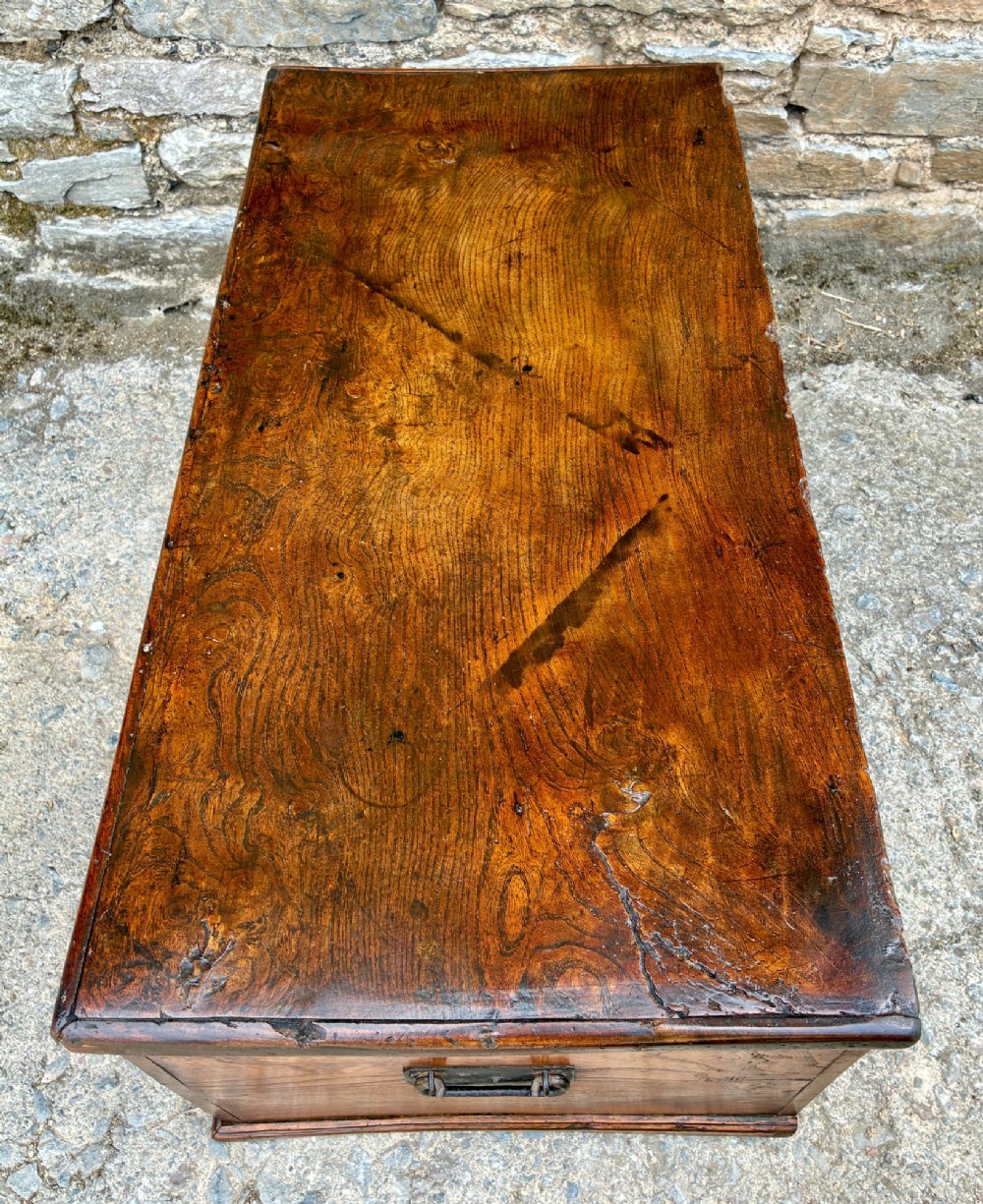 A rectangular antique elm blanket box featuring a hinged lid, visible wood grain, and a central keyhole escutcheon. View XI