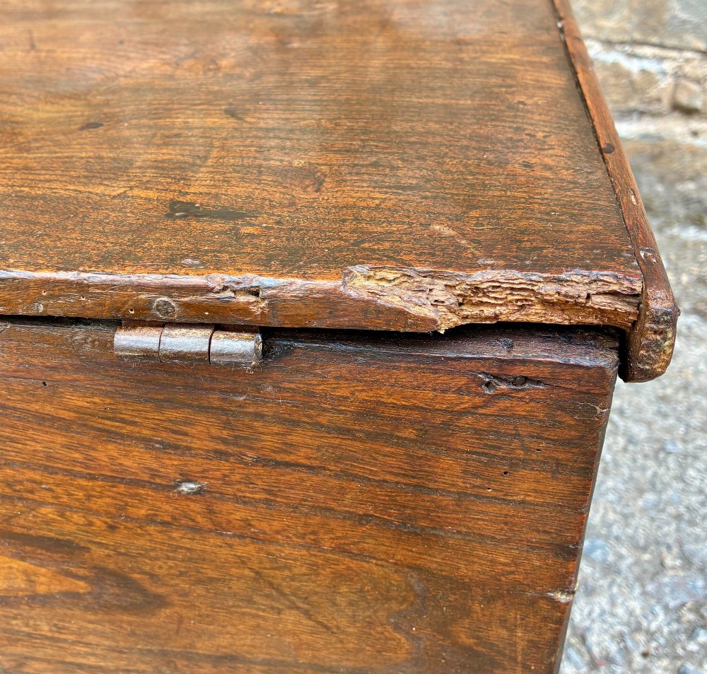 A rectangular antique elm blanket box featuring a hinged lid, visible wood grain, and a central keyhole escutcheon. View XIII