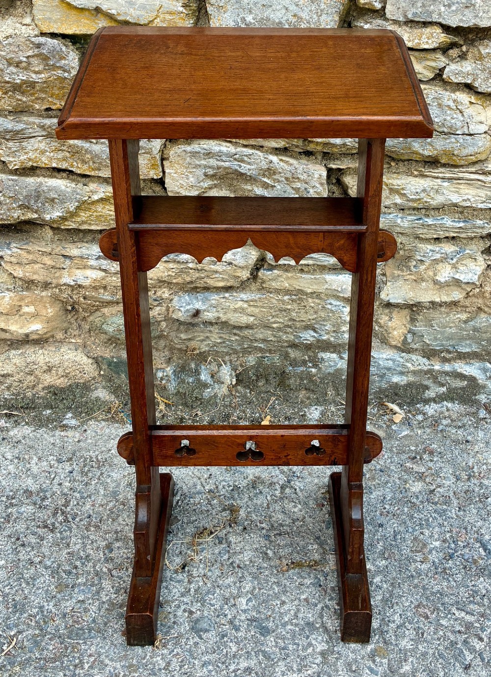 A small antique dark oak church lectern featuring a slanted reading top, trefoil cutouts, and a trestle base.